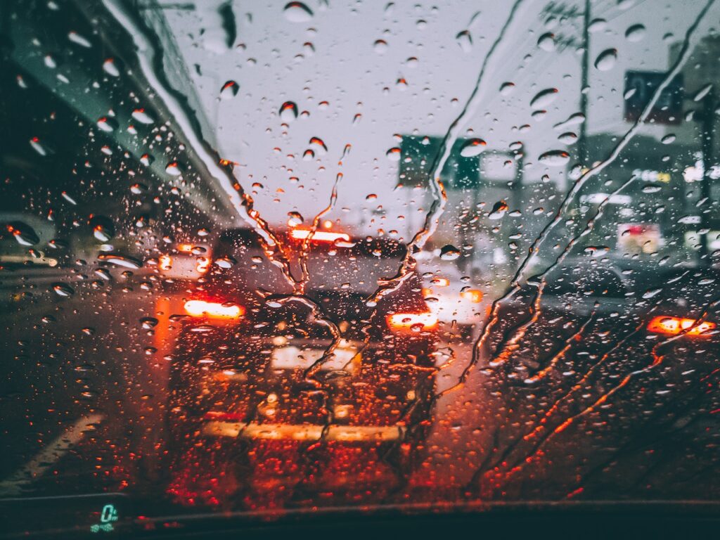 An inside perspective of a car in the rain